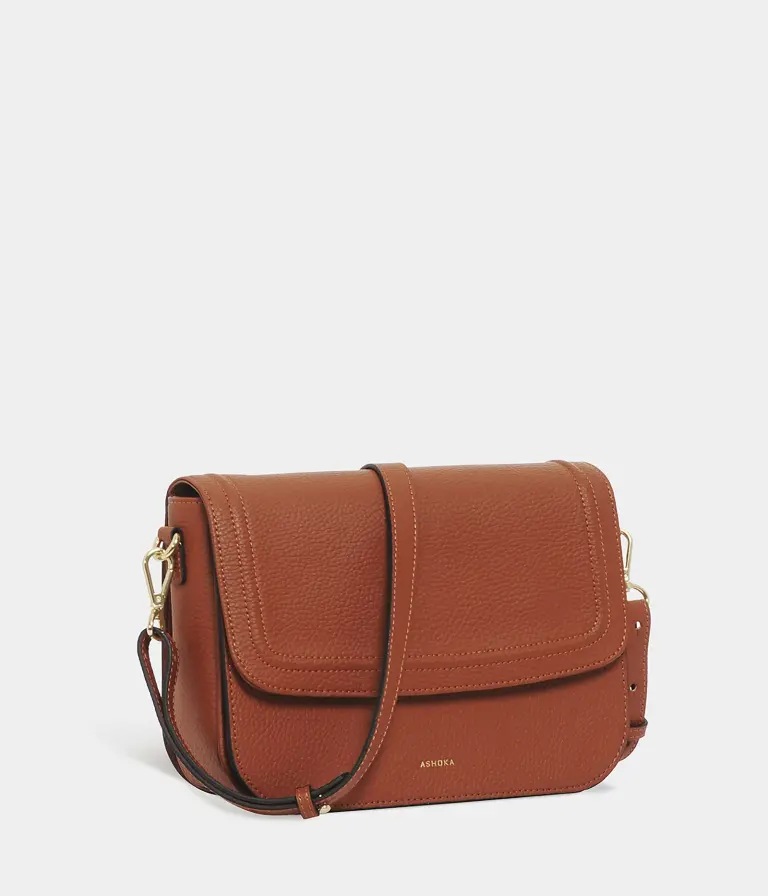 A tan leather crossbody bag with a flap and adjustable strap