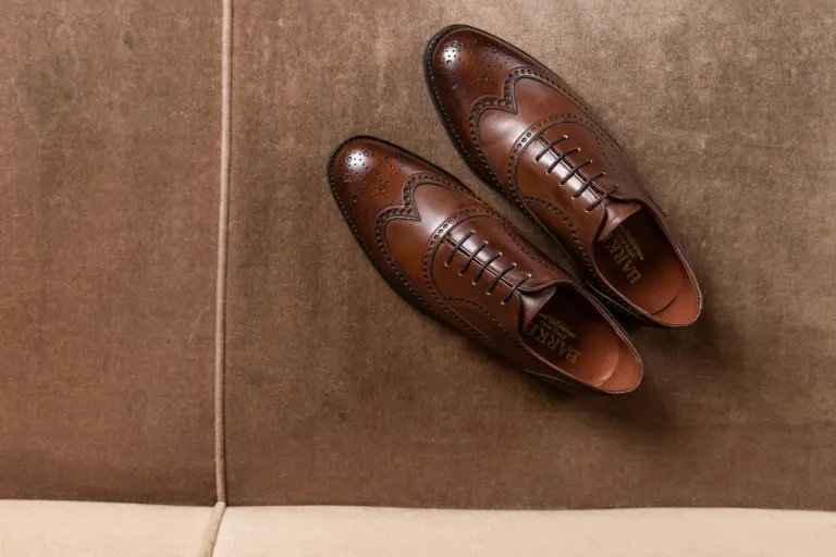 A pair of brown leather Oxford shoes on a bench