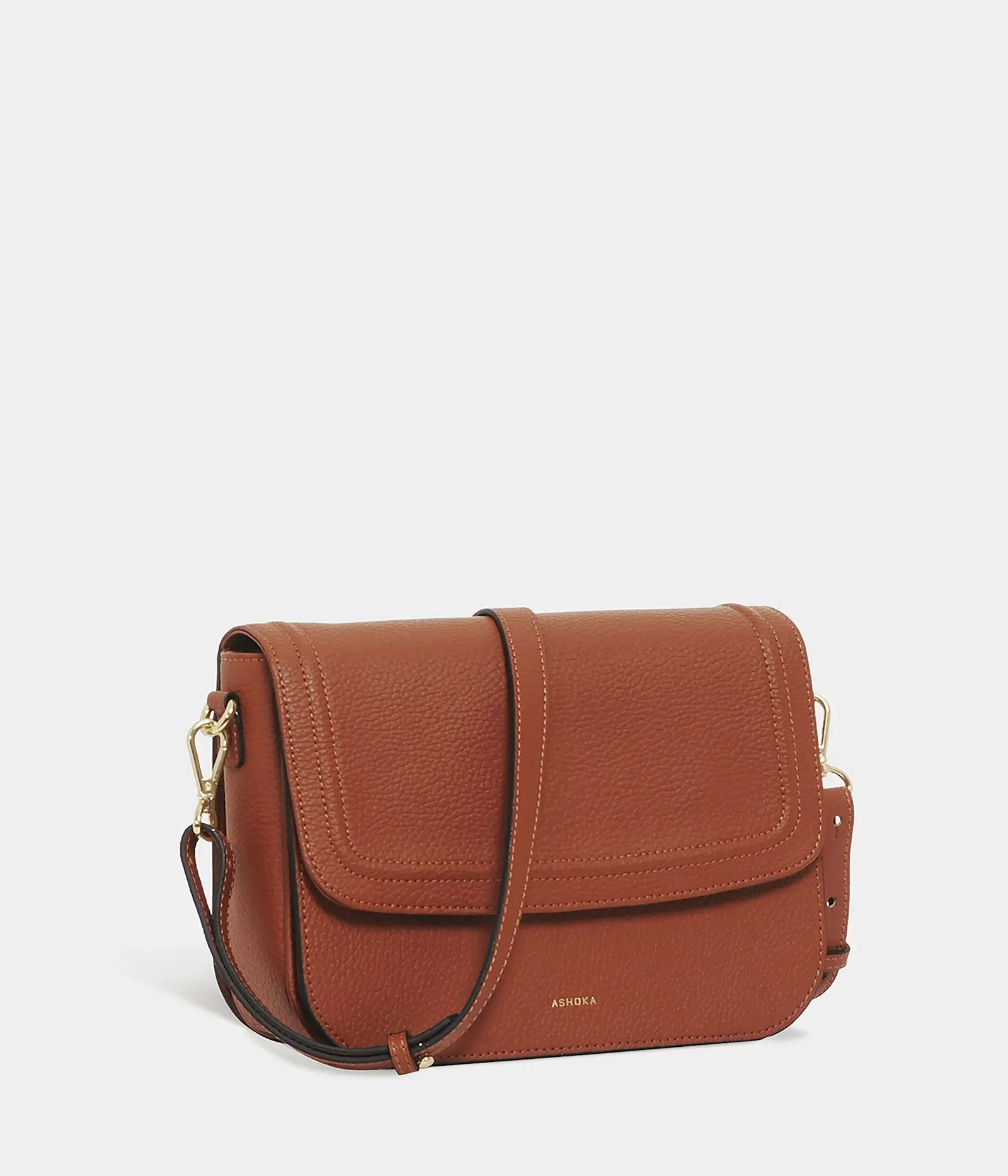 A tan leather handbag with a flap and shoulder strap